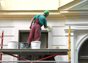An exterior painter working on a home in Guilford
